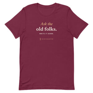 Maroon unisex t-shirt printed "Ask the old folks" with The Sip Collective microphone logo
